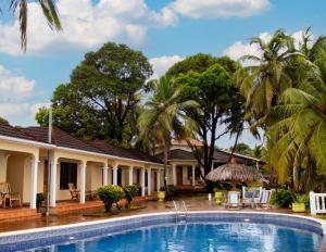 a pool in front of a house with palm trees at Hotel Casa Canada in Big Corn Island