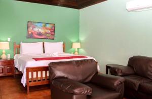 Hotel Casa Canada في جزيرة بيغ كورن: غرفة نوم بسرير مع أريكة وكرسي