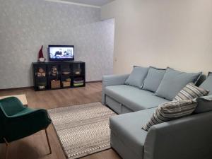 uma sala de estar com um sofá e uma televisão em Apartment near Akropolis em Klaipėda