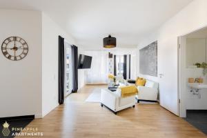 德勒斯登的住宿－Pineapple Apartments Dresden Altstadt V - 112 qm - 1x free parking，客厅配有白色家具和墙上的时钟