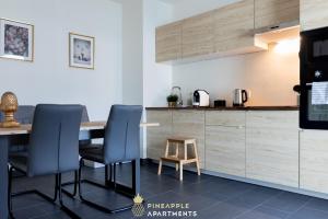 een keuken met een tafel, 2 stoelen en een aanrecht bij Pineapple Apartments Dresden Altstadt V - 112 qm - 1x free parking in Dresden