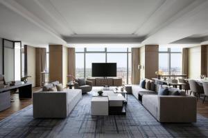 a living room with couches and a flat screen tv at Zhangjiagang Marriott Hotel in Zhangjiagang