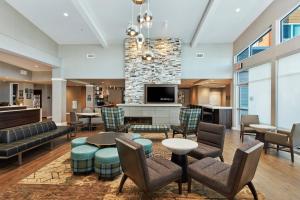 a lobby with chairs and tables and a fireplace at Residence Inn Sacramento Davis in Davis