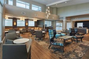 a lobby with a waiting room with chairs and tables at Residence Inn Sacramento Davis in Davis