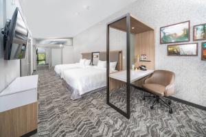 a hotel room with a bed and a desk and a mirror at SpringHill Suites Island Park Yellowstone in Island Park