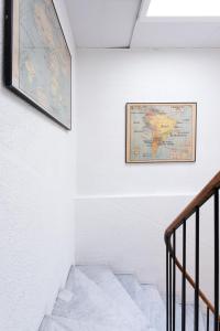 a map hanging on a wall next to a staircase at Hotel De Belgique à Menton in Menton