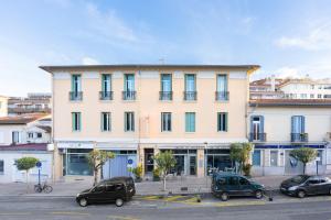 a large building with cars parked in a parking lot at Hotel De Belgique à Menton in Menton