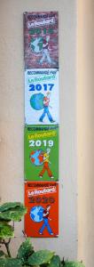 two posters on the side of a wall at Hotel De Belgique à Menton in Menton