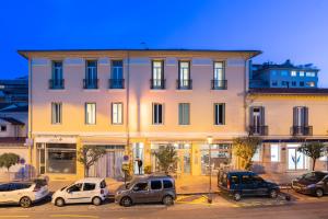 a large building with cars parked in a parking lot at Hotel De Belgique à Menton in Menton