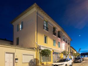 a yellow building with a car parked in front of it at Hotel De Belgique à Menton in Menton