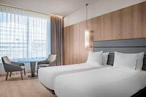 ein Hotelzimmer mit einem großen Bett und einem Tisch in der Unterkunft AC Hotel Diagonal L'Illa by Marriott in Barcelona