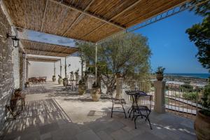 un patio con sillas, mesas y techo de madera. en RoccaSeta, en Scicli