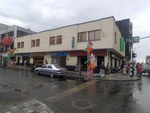 a building on a street with a car parked in front at Hotel imperio cafetero in Armenia
