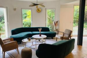 een woonkamer met een groene bank en stoelen bij La Villa Candau - Cowork & Fun - Piscine - Wifi Fibre in Les Angles Gard