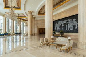 a large lobby with columns and a large painting on the wall at The St. Regis New Capital Cairo in Cairo