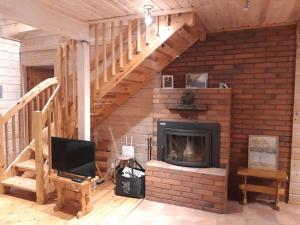 sala de estar con chimenea y escalera en Vihreä Helmi, en Kuusamo