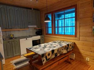 cocina con mesa en el centro de una habitación en Vihreä Helmi, en Kuusamo