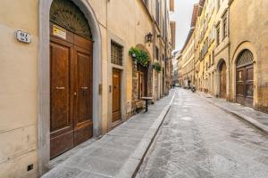 an empty street in an alley with wooden doors at Art Apartment Luxury Sofia Suite in Florence