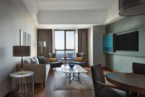 イスタンブールにあるイスタンブール マリオット ホテル アジアのリビングルーム(ソファ、椅子、テレビ付)