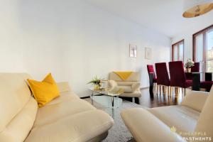 a living room with a couch and a table at Pineapple Apartments Palais am Neumarkt - 90 qm - 1x free parking in Dresden