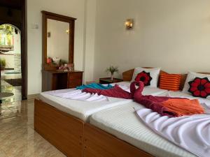 een groot bed met een deken erop bij Kandy IVY Banks Holiday Resort in Kandy