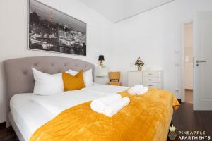 een slaapkamer met een groot wit bed en handdoeken bij Pineapple Apartments Palais am Neumarkt - 90 qm - 1x free parking in Dresden