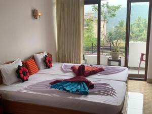 een groot bed in een kamer met een groot raam bij Kandy IVY Banks Holiday Resort in Kandy
