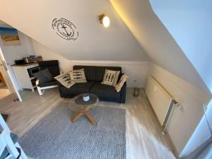 a living room with a couch and a table at Oceanblue Appartements - Laboe in Laboe
