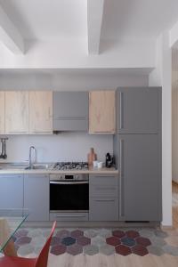 una cucina con armadi bianchi e piano cottura di Olimpico Apartment - Zen Real Estate a Roma