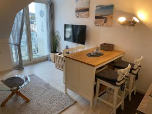 a living room with a desk and a tv at Oceanblue Appartements - Laboe in Laboe