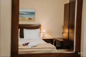 a reflection of a bedroom with a bed in a mirror at Amalthea Sivota in Sivota