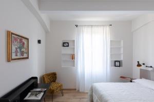 ローマにあるOlimpico Apartment - Zen Real Estateのベッドルーム1室(ベッド1台、デスク、窓付)