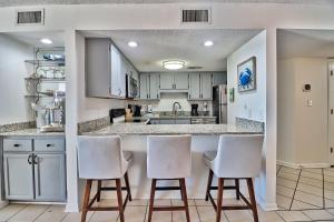a kitchen with white cabinets and white bar stools at Direct Ocean Front 3BR/2BA Dog Friendly in Myrtle Beach