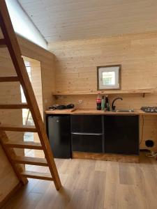 a kitchen in a log cabin with a sink at Chambre Privée Chez l'Habitant in Capbreton
