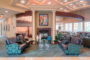 vestíbulo con sillas de cuero y chimenea en Residence Inn by Marriott Chapel Hill en Chapel Hill