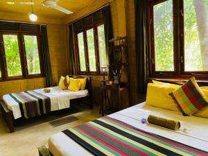 a room with two beds and two windows at Kandy Eco Retreat in Kandy