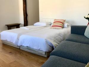 een slaapkamer met 2 bedden en een bank bij Antigua Casa Pescadores Vista Panorámica in Bermeo