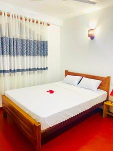 Schlafzimmer mit einem Bett und einem roten Teppich in der Unterkunft The River Villa in Talpe