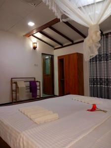 Schlafzimmer mit einem Bett mit weißer Bettwäsche und Vorhängen in der Unterkunft The River Villa in Talpe