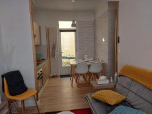 salon z kanapą i stołem z krzesłami w obiekcie L'Appartement Gabriel T2 w mieście Bergerac