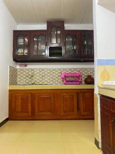 a kitchen with wooden cabinets and a counter top at The River Villa in Talpe
