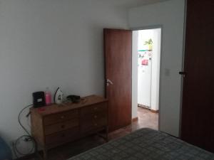 1 dormitorio con vestidor y puerta con nevera en san vicente en Olavarría