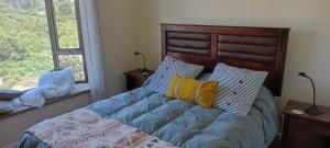 um quarto com uma cama com uma cabeceira e almofadas de madeira em Acogedor Apartamento, rodeado de Naturaleza y Mar. em Puerto Montt