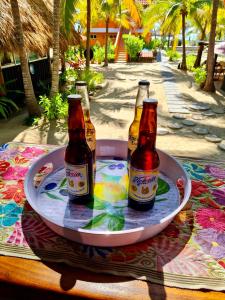 tres botellas de cerveza en un plato en una mesa en Bungalows Tree Tops - Adults Only, en Zihuatanejo