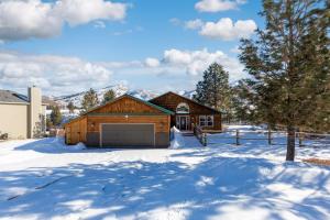 uma casa com garagem na neve em Twin Pines Cabin in Wilderness Ranch on Hwy 21, AMAZING Views, 20 ft ceilings, fully fenced yard, pet friendly, , Go paddle boarding at Lucky Peak, or snowshoeing in Idaho City and take in the hot springs, sleeps 10! em Boise