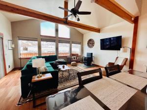 un soggiorno con divano e ventilatore a soffitto di Twin Pines Cabin in Wilderness Ranch on Hwy 21, AMAZING Views, 20 ft ceilings, fully fenced yard, pet friendly, , Go paddle boarding at Lucky Peak, or snowshoeing in Idaho City and take in the hot springs, sleeps 10! a Boise