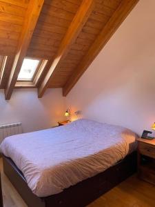 a bedroom with a large bed in a attic at Apartamento familiar en Benasque in Eriste