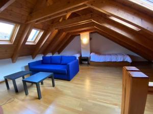 sala de estar con sofá azul y cama en Apartamento familiar en Benasque, en Eriste
