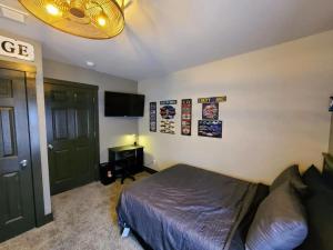 a bedroom with a bed and a flat screen tv at King Bed In Main Floor - Downtown Vacation Rental in Kalamazoo