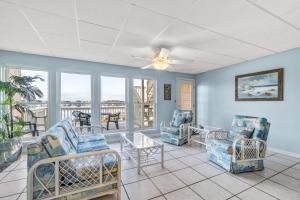 een woonkamer met stoelen en een tafel bij The Treehouse On the Bay in Pensacola Beach